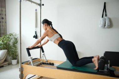 Göğüs ve kol kaslarını güçlendirmek için şınav çeken güçlü genç bir kadın.