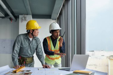 İnşaat alanındaki ekiple iletişim kurmak için telsiz kullanan duygusal ustabaşı.