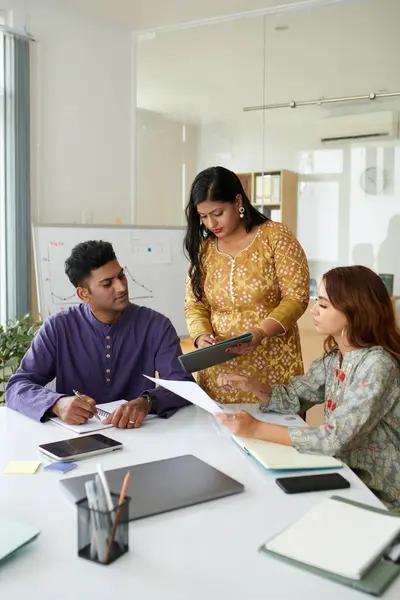 Indian businesswoman discussing results of marketing campaign with colleagues in meeting