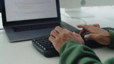 Bilgisayarın önünde oturan tanımlanamayan kodlayıcının ellerini kapat.