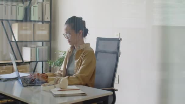 潘妮拍摄的一个穿着休闲装 坐在办公室玻璃墙后面的电脑上工作的女人的照片 — 图库视频影像