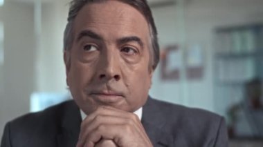 Ofisteki iş meselelerini düşünen takım elbiseli, yorgun ve yaşlı bir adama yaklaş.