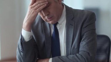 Ofiste fazla mesai yaparken erkek girişimcinin baş ağrısı çekmesini çek