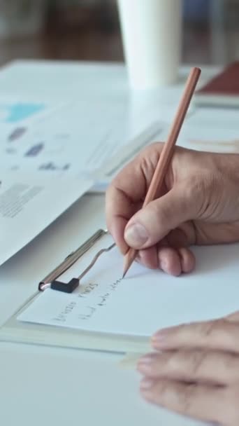 Ofiste Çalışırken Tanınmayan Bir Ofis Çalışanının Planını Kağıda Yazmasının Dikey — Stok video