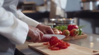 Restaurantın soğuk hazırlık bölümünde sebze doğrayan tanınmayan aşçı yamağı.