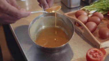 Restoranda yumurta ve soğanla yemek pişirirken makarna sosu hazırlayan tanınmamış şefin ellerini kapatın.