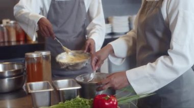 Hamur ya da püre pişiren ve birbirleriyle konuşan çok ırklı aşçı yamaklarını yavaşça yukarı kaldır.