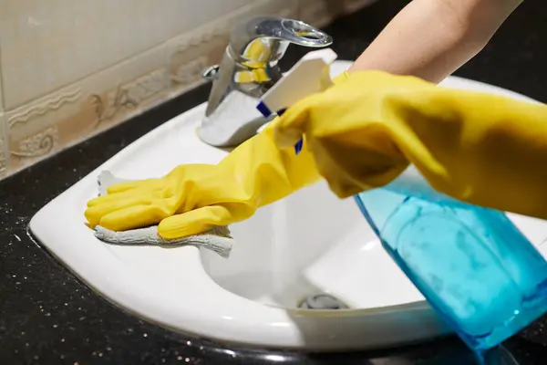 保護ゴム手袋の女性のクローズアップ トイレでラグとスプレーで洗浄シンク — ストック写真