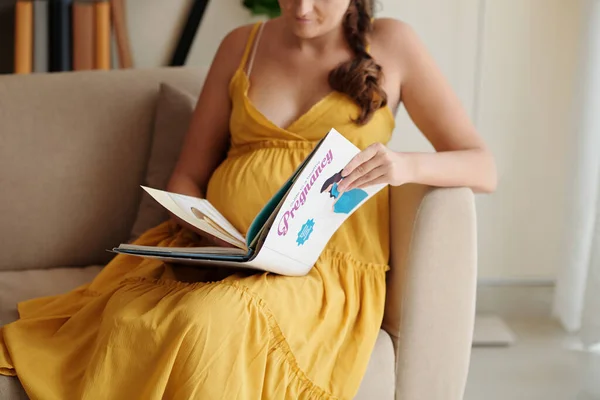 为在休产假期间阅读有关怀孕问题书籍的年轻怀孕少女提供特写 — 图库照片