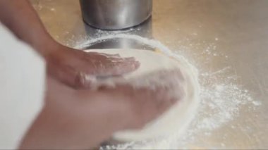 Restoranda yemek pişirirken un kullanarak pizza ya da turta için hamur işi yapan tanınmamış şefin ellerini kapatın.