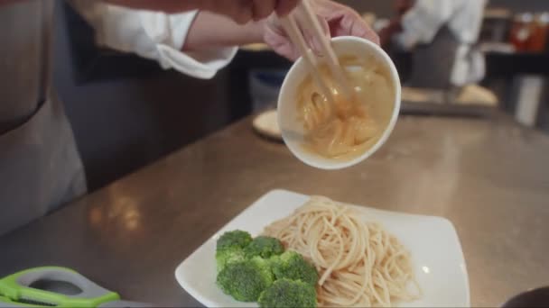 Handheld Close Cook Adding Egg Sauce Plate Pasta Broccoli While — Stock Video