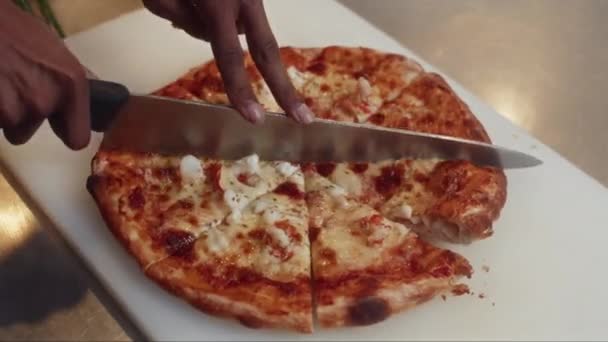 認識できない家庭料理やシェフの手を閉じる サービング前にチーズとトマトでピザを切る — ストック動画