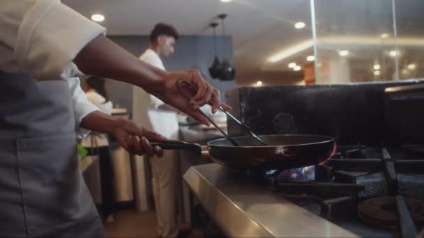 ホテルのレストランシェフがキッチンでパンを使った肉や魚を揚げたショット — ストック動画