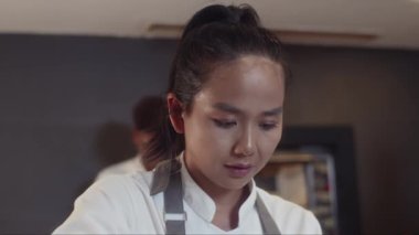 Restoran misafirlerine servis etmeden önce Asyalı kadın aşçının deniz mahsulleri makarnasını bitirmesi.