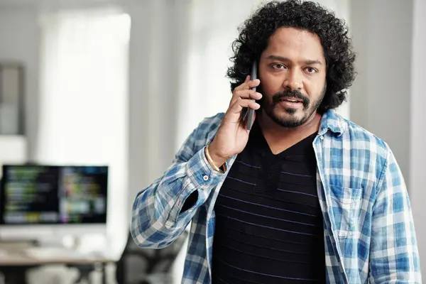 Portrait of Indian startup founder talking on phone when leaving office