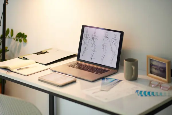 Hand drawn fashion sketches on laptop screen home office concept