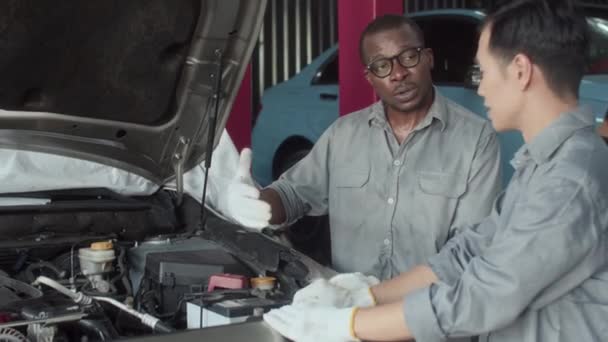 Ręczne Ujęcie Wieloetnicznych Mechaników Omawiających Naprawę Samochodu Awarią Wewnątrz Maski — Wideo stockowe