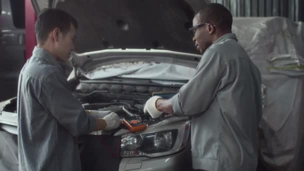 Hátsó Nézet Két Különböző Férfi Vizsgálja Autó Motor Multiméter Alkalmazás — Stock videók