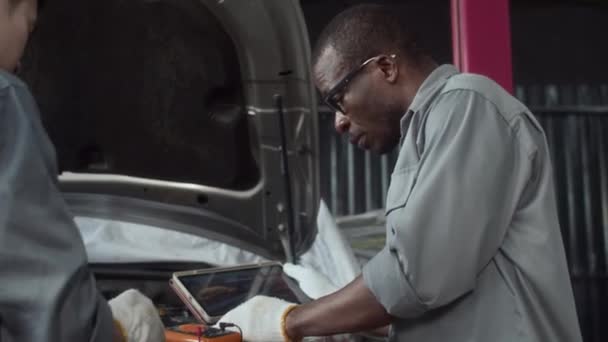 Colaboradores Multiculturales Inspeccionando Trabajo Del Motor Del Automóvil Con Tableta — Vídeos de Stock