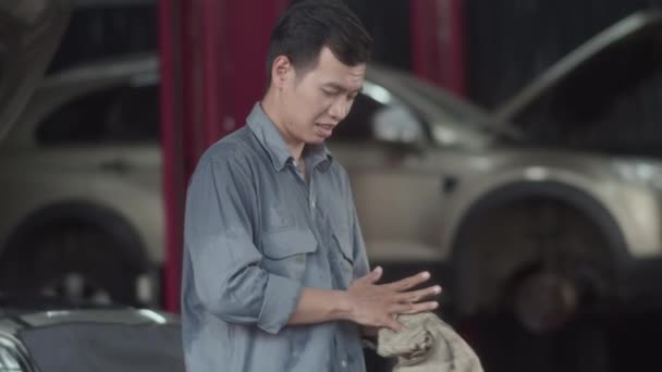 Średnie Ujęcie Męskiego Mechanika Wycierającego Ręce Wymianie Oleju Maszynowego Samochodzie — Wideo stockowe