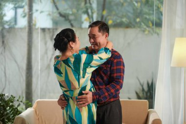 Yaşlı Vietnamlı aşık çift odanın ortasında dans ediyor.