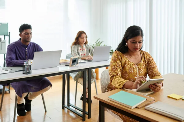 Koncentrerad Indisk Affärskvinna Läser Rapport Surfplatta Dator När Arbetar Kontoret — Stockfoto