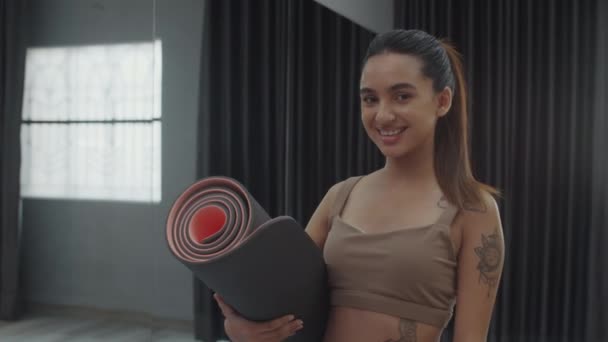 Potret Sedang Gadis Asia Memegang Tikar Yoga Menatap Kamera Selama — Stok Video