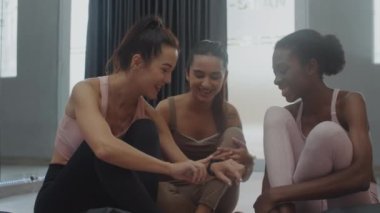 Yoga dersinden sonra akıllı sepetteki fitness aktivitesini tartışan orta ölçekli kadınlar.