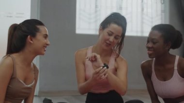 Çok kültürlü bayan sporculardan oluşan orta ölçekli bir grup. Stüdyoda yeni spor uygulamasını tartışıyorlar.