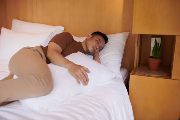 Ung Man Sover Med Kudde Mellan Benen Vilket Håller Bäckenet — Stockfoto