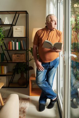 Cam giriş kapısında duran ve dışarıyı seyreden son sınıf öğrencisi.