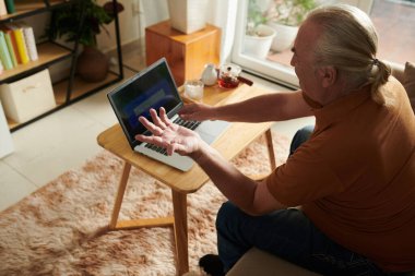 Şaşkın ve sinirli yaşlı adam şifreyi unuttuğu için web sitesine giremiyor