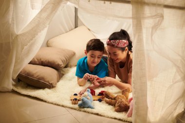 Anne ve oğlu oyuncaklarla oynayarak vakit geçirmekten zevk alıyorlar.