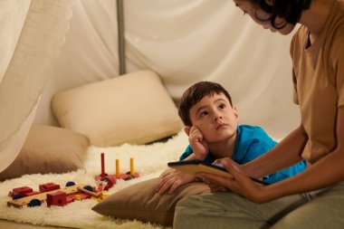Meraklı küçük çocuk hafta sonunu birlikte geçirirken annesine bakıyor.
