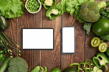 Akıllı telefon ve tablet bilgisayar ahşap masa üzerinde taze bakkaliye, üst görünüm