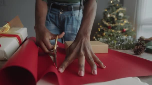 圣诞前夕 女人在给朋友包装礼物时剪下红纸的剪影 — 图库视频影像