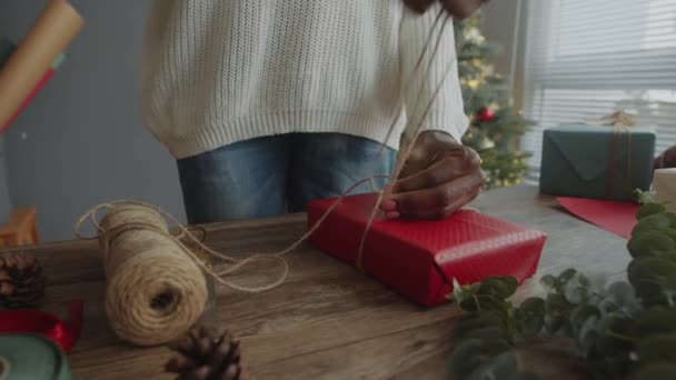 Przycięte Ujęcie Czarnej Kobiety Pomocą Sznurka Podczas Pakowania Świąteczny Prezent — Wideo stockowe
