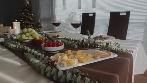 チーズキューブ ハムスライス トマト ワイン アペタイザーのミディアムクローズアップは 居心地の良いリビングルームでXmasのお祝いのために準備 — ストック動画