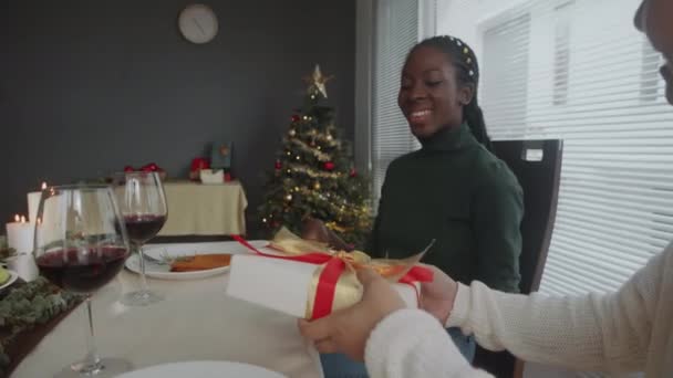 Портативный Снимок Молодой Черной Женщины Принимающей Рождественский Подарок Друга Сидящего — стоковое видео