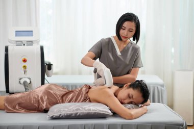 Güzellik uzmanının kuaförde saçlarını taraması.