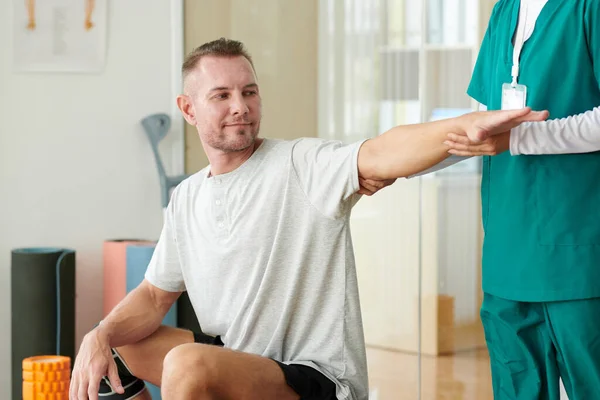 Verpleegster Vraagt Patiënt Uit Breiden Arm Gespannen Spieren — Stockfoto