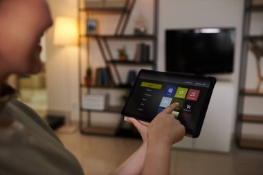 Tablet bilgisayarda akıllı televizyon uygulamasını açan kadının elleri