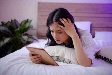 Asık suratlı genç kız tablet bilgisayarda üzücü haberler okuyor, kıyamet günü konsepti