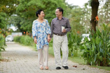 Parkta yürüyen neşeli Vietnamlı çift.