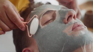 Güzellik stüdyosunu gezerken maske ve paten takan genç bir adamın büyük bir yakın çekimi.