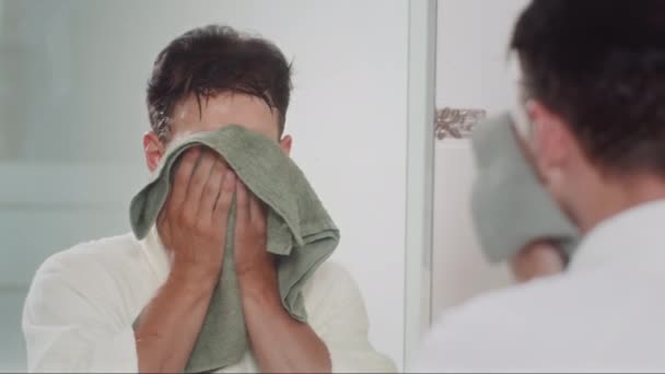Przez Ramię Młodego Mężczyzny Białym Szlafroku Wycierającego Twarz Zielonym Ręcznikiem — Wideo stockowe
