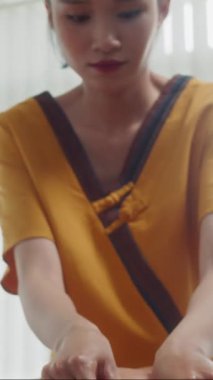 Spa salonu uzmanının terapi sırasında kanepede uzanan adamın sırtına masaj yaparken dikey pozu.