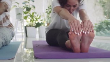 Yavaşça genç melez erkek ve kadın vücutlarını yere sererken ayaklarına doğru çekiyorlar.