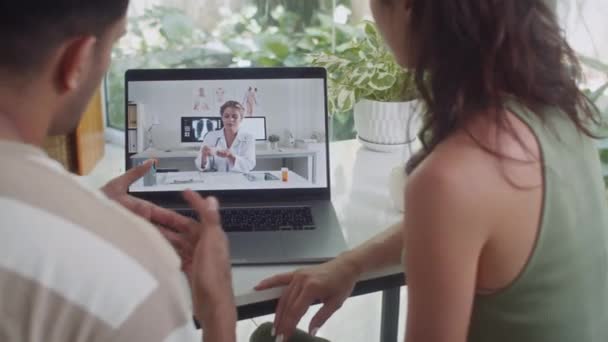 在家中 一对男女与女医生坐在无线膝上型计算机前进行视频通话时被截回的镜头 — 图库视频影像