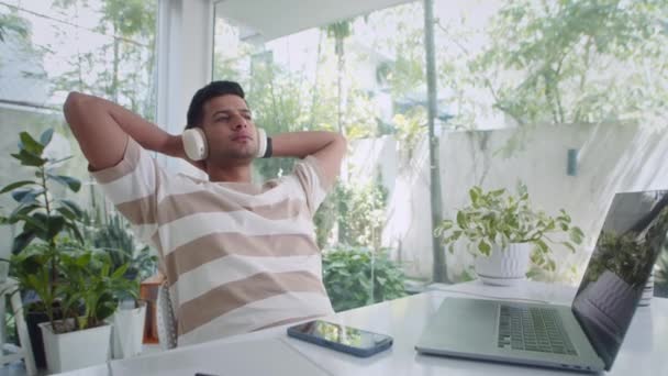 Genç Hintli Adamın Sandalyede Oturup Kulaklıkla Müzik Dinlediği Akıllı Telefonlu — Stok video